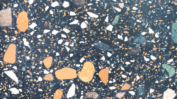 黑白照片，岩石表面，有各种彩色的石头。照片有一种忧郁而神秘的氛围，石头以看似随机的图案散布着。图片下载