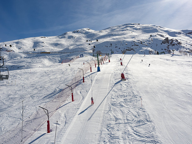 寒冷晴天滑雪场上滑雪者滑下的照片图片下载