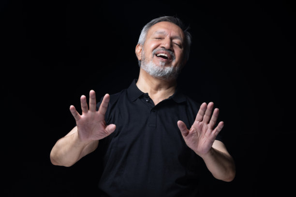 穿着黑色T恤的老年男性，在黑色背景下拍摄的照片素材图片下载