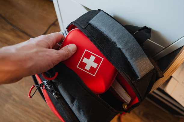 这张照片捕捉到一只手伸向背包内急救箱的瞬间，体现了健康、准备和医疗护理的主题图片下载