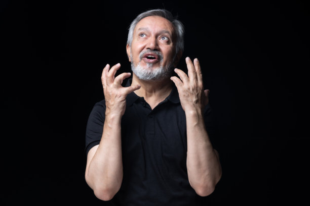 身穿黑色T恤的老年男子，在黑色背景上拍摄的素材照片图片下载