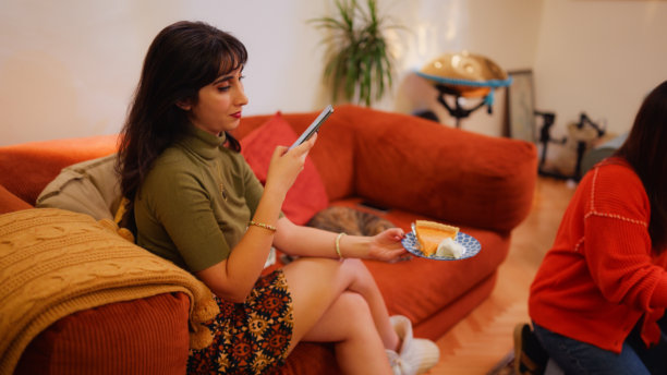 年轻女子在派对上用智能手机拍摄南瓜派的照片图片下载