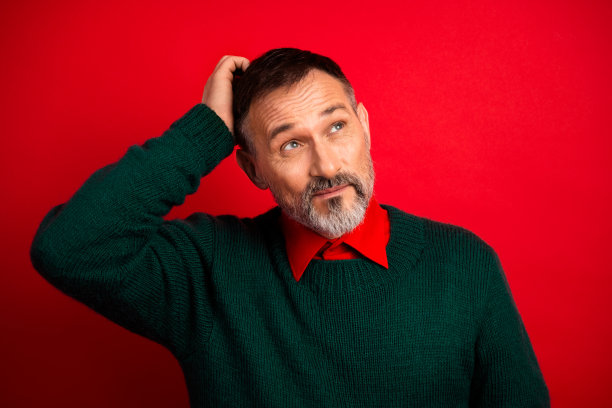 周末圣诞毛衣神秘男子挠头，为节日素材摆拍图片下载