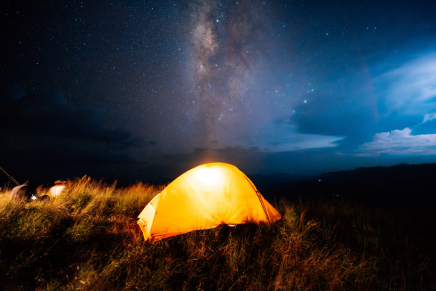 夜幕下的山间露营，仰望星空与银河。旅行与徒步概念。图片下载