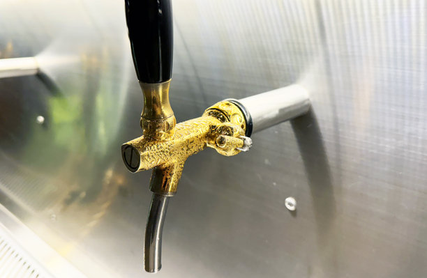 特写黄铜啤酒龙头正在出酒。图片下载