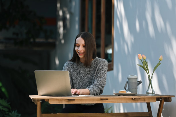 一位白人女性自由职业者在花园的办公区用笔记本电脑打字图片下载