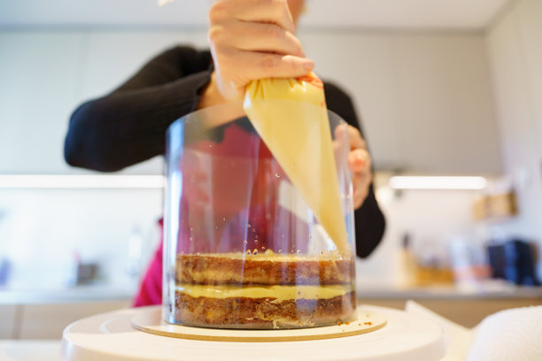 糕点师在蛋糕模具中分层奶油图片下载