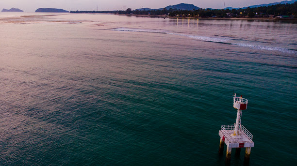 从上方拍摄的孤独海洋灯塔，周围是无尽的蓝色海水。图库照片图片下载