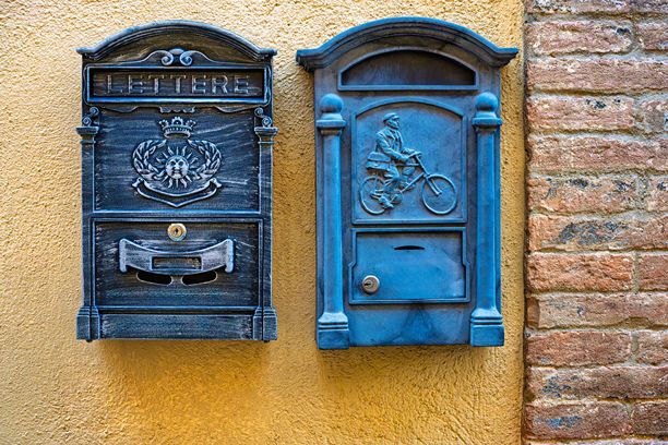 带有纹理的黄色墙壁上的两个复古邮箱。图片下载