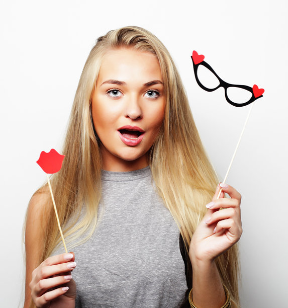 派对图片。年轻俏皮的女子拿着派对眼镜。图片下载