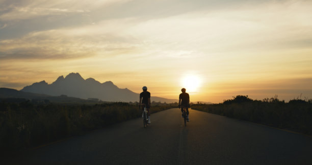 夕阳下，朋友们骑着自行车在乡村赛道或探险小径上享受运动、竞赛或探险。人们骑着山地自行车进行户外锻炼、挑战和健康训练。图片下载
