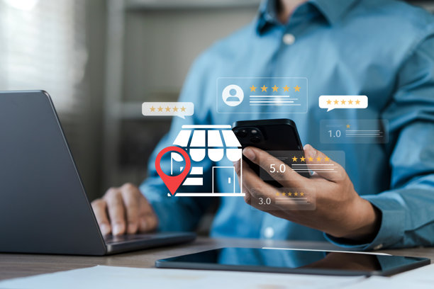 搜索引擎优化，商人使用智能手机和笔记本电脑，带有数字商店图标、定位图钉和客户评价星级。概念用于本地商家营销、在线评分和品牌声誉管理。图片下载