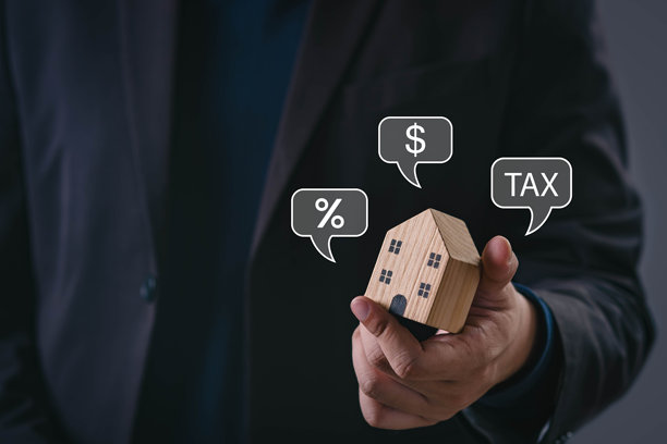 商人拿着木屋模型，旁边有税收、美元和百分比图标，象征着房地产税、物业投资、抵押贷款利息、财务规划和住房市场战略。图片下载