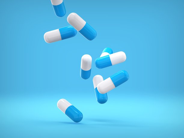 蓝色的背景上掉落着蓝白色的药丸胶囊。3D插画图片下载