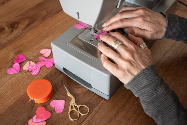 用缝纫机将手绘纸心缝制成花环，手工制作图片下载