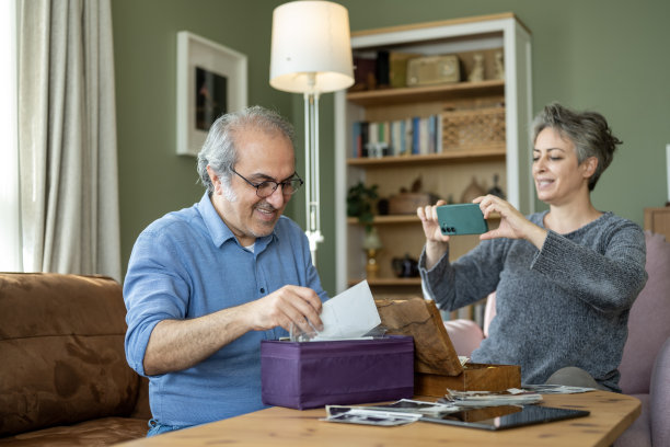 一对快乐的中老年夫妇看着老照片，回忆往昔图片下载