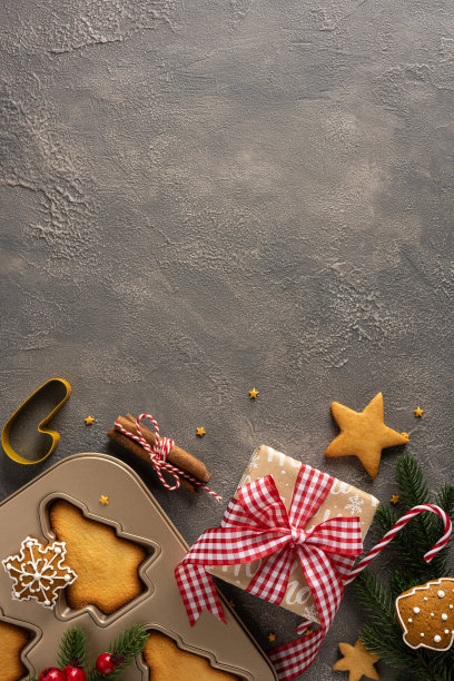 节日垂直场景，烘焙烤盘上放着包装好的礼物、饼干模具、拐杖糖和常青枝图片下载