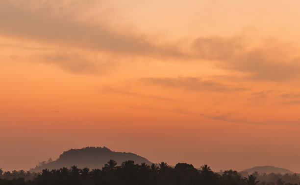 宁静的日落景象，橙色暖阳，朦胧的山峦，背景照片图片下载