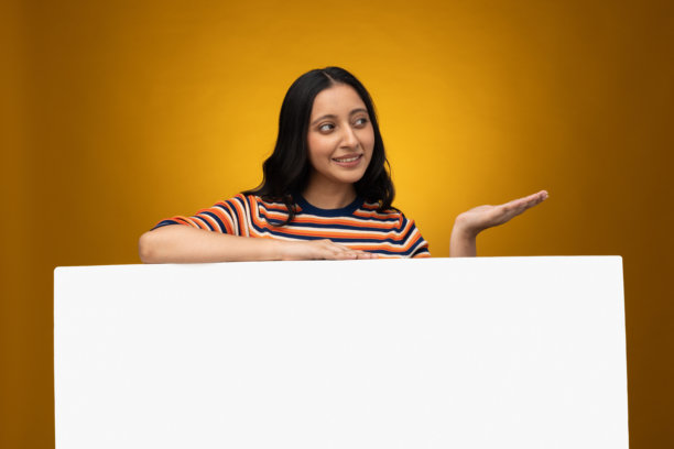 年轻女子手举横幅，背景为黄色隔离的招牌图片素材图片下载
