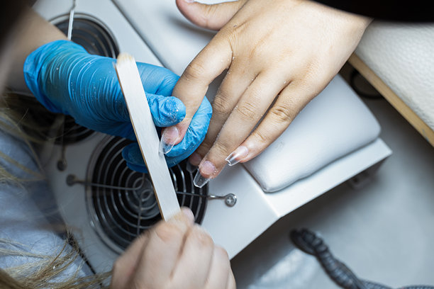 美甲师在美容院为顾客修剪指甲的素材照片图片下载