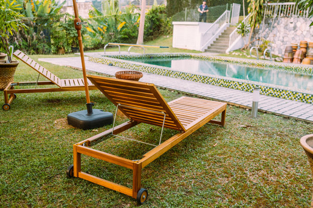 热带庭院游泳池旁的木制躺椅照片图片下载