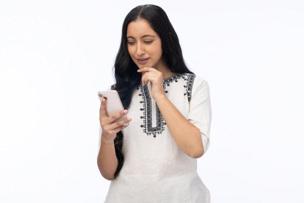 身穿库尔塔的年轻女子使用手机，白色背景单独照片图片下载