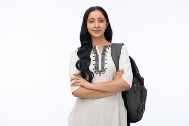 年轻女学生背着包，穿着库尔塔，在白色背景下拍摄的肖像照片图片下载