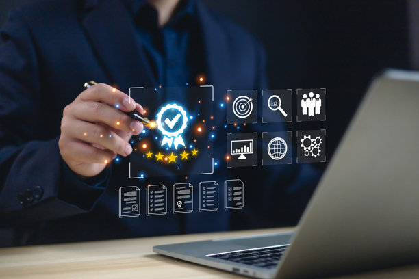 商务人士使用数字笔，笔记本电脑屏幕上显示全息质量认证图标和五星好评，象征着标准认可、客户满意度和卓越的商业成就。图片下载