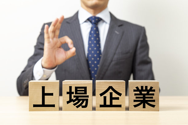 一位商人摆出OK姿势，旁边有一个写着“上市公司”的方块。图片下载