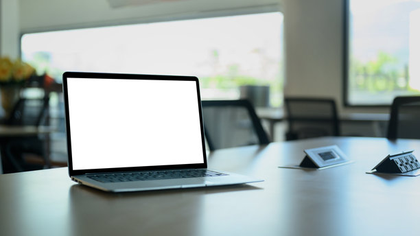 会议桌上的笔记本电脑，屏幕空白。图片下载