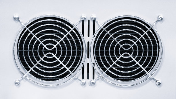 现代电脑电源单元的金属格栅后方的风扇，用于冷却电脑及其组件。白色背景。照片。特写。图片下载