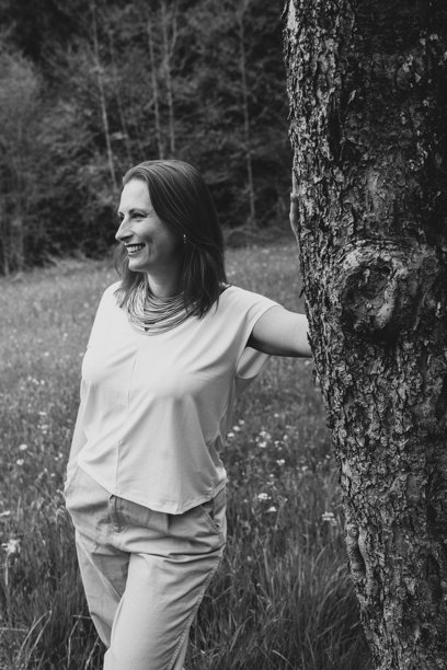 中年女性在春季花园盛开的树旁微笑。寓意女性健康、荷尔蒙平衡、养生和中年自然美。图片下载