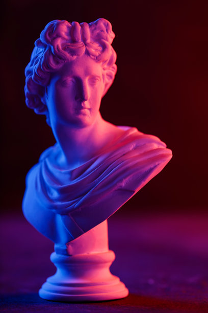 深色背景下带有粉色和蓝色霓虹灯对比的石膏头像图片下载