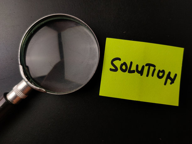 一张带有“SOLUTION”字样的黄色便利贴和放大镜的图片图片下载