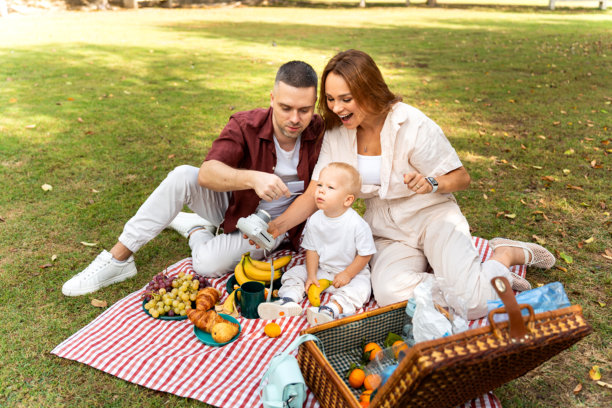 快乐的一家人户外野餐，正在拍即时照片图片下载