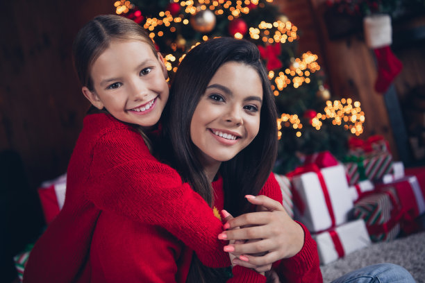 照片：穿着红色毛衣的梦幻迷人的小兄妹俩在圣诞公寓的室内开心地玩耍图片下载