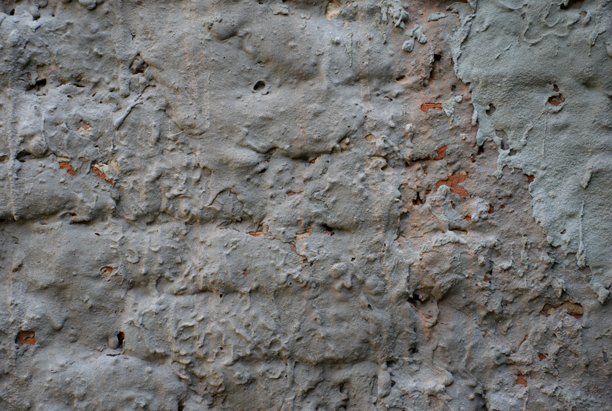 饱经风霜的古老乡村墙壁，剥落的灰泥和露出的砖块。粗糙的污垢纹理背景。适用于城市、工业、复古或建筑设计。图片下载