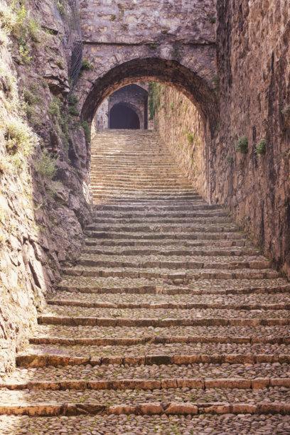 布雷西亚城堡内部的复古风格照片，展示了拱形通道和带有温暖怀旧色调的纹理墙壁图片下载