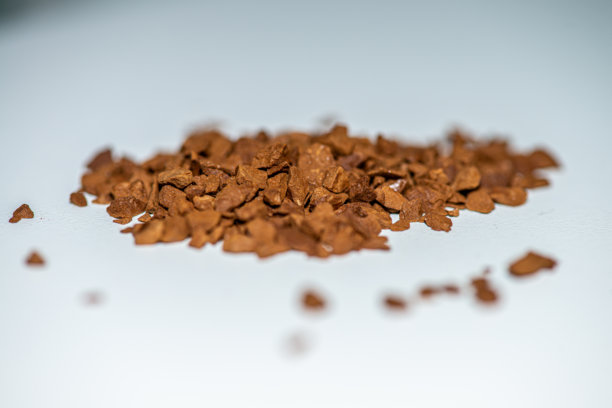 白色背景下，勺子装满咖啡豆的微距照片图片下载