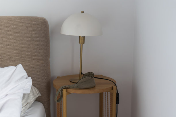 格但斯克现代化公寓里的极简床头，配有台灯和床头柜图片下载