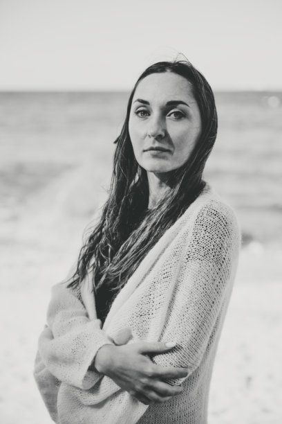 黑白照片：一位年轻女子在波罗的海海边沉思的肖像图片下载