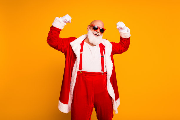 身着亮红色镶白毛服装的圣诞老人，在鲜亮的黄色工作室背景中欢快起舞，适用于圣诞节和节日季的营销图片图片下载