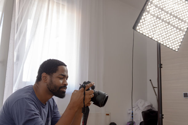 男摄影师手持相机，进行专业的照片拍摄图片下载