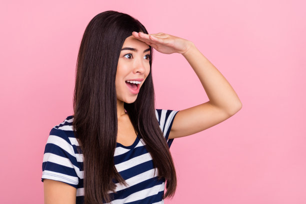 年轻千禧一代女士的个人资料照片，欢呼雀跃，穿着条纹T恤，孤立在粉彩粉色背景上图片下载