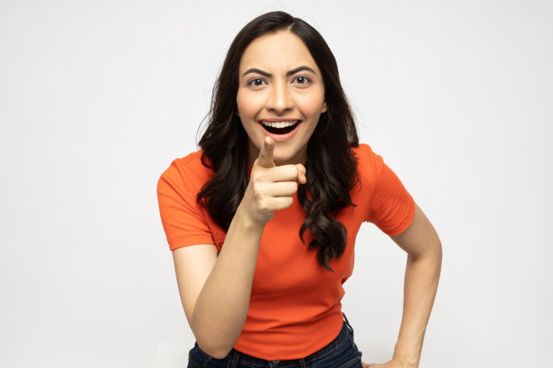 穿着橙色T恤的漂亮年轻女子照片，白色背景隔离图片下载