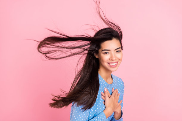 年轻女孩的个人资料侧面照片，面带快乐积极的微笑，双手放在胸前，表达感恩感谢，在粉色背景上孤立。图片下载