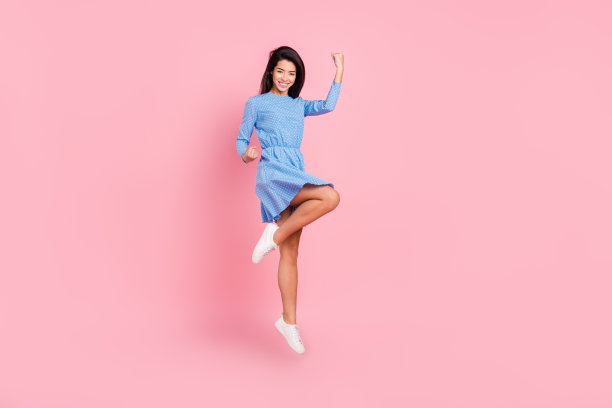 年轻女孩全身侧面照片，快乐积极的微笑，庆祝胜利的成功，握紧拳头，双手，孤立在粉色背景上图片下载