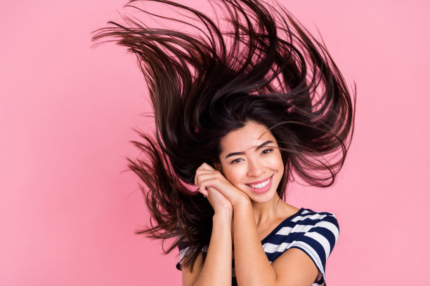 照片：年轻貌美的千禧一代女士，戴着条纹T恤，双手捂脸，背景为粉彩色调图片下载