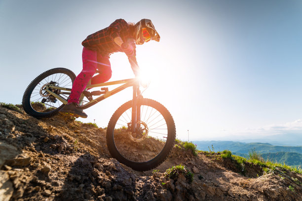 骑山地自行车的男人在户外骑行。戴头盔的男性游客在山间草地上骑自行车。运动、户外活动和自然概念图片下载