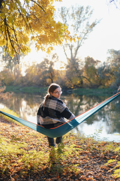 年轻女子在森林中享受宁静的吊床时光——素材照片图片下载